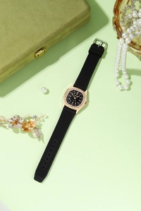Detailed macro of rose gold square watch with crystal bezel and black rubber strap