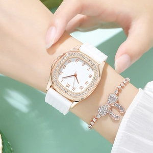 Detail of rose gold rhinestone square watch and bow bracelet on woman's wrist
