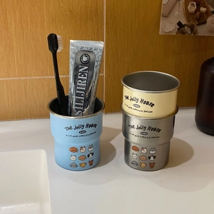 Three stainless steel cups with cute cartoon dogs and branding on a vanity counter