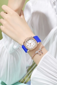Detail of square rose gold watch with blue silicone strap and diamond bow bracelet