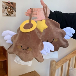 Detail of star-shaped plush tissue bag with angel wings being held in a cozy bedroom