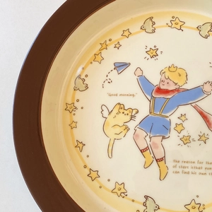 Close-up of The Little Prince ceramic plate featuring vintage star and character artwork