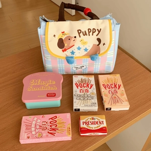 Detailed view of plaid puppy lunch bag with matching bread-shaped bento box on table