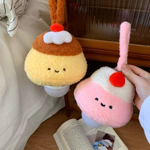 Detail of cute pudding plush night lamps in yellow and pink hanging by bedside