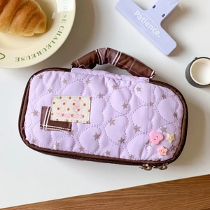 Detailed view of purple quilted pencil case with heart texture and star patterns