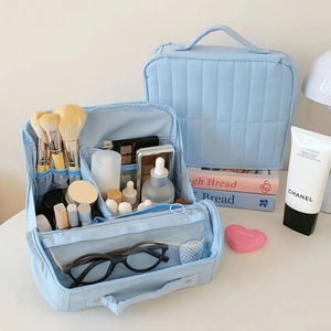 Internal compartments of a light blue quilted travel cosmetic bag for organized storage