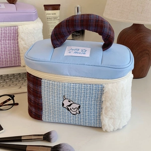 Detail of multi-material patchwork makeup bag with plush fabric and dog pattern