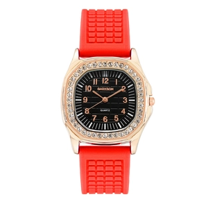 Detailed macro of a luxury quartz watch with diamond bezel and red silicone strap