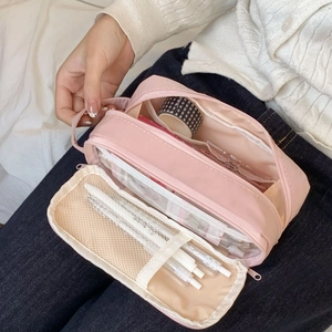 Close-up of pink large capacity storage bag with multiple mesh compartments and zippers