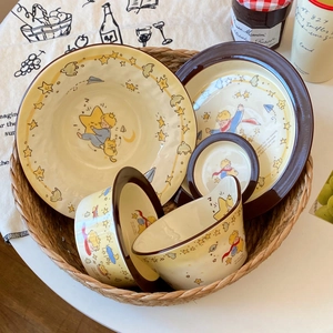 Detailed ceramic tableware set featuring The Little Prince illustrations in a woven basket