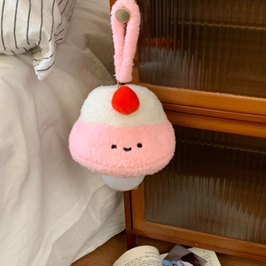 Close-up of a plush strawberry-topped night light hanging on a wooden handle