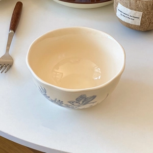 Detail of vintage ceramic bowl with wavy edge and blue bird floral patterns