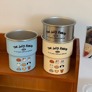 Detail of stacked stainless steel cartoon dog mugs in blue, beige and silver colors