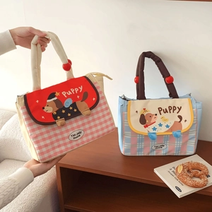 Detail of insulated lunch bags with dog illustrations and comfortable rounded handles