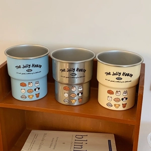 Detail of blue, steel, and yellow stainless steel dog cups on a rustic wooden shelf