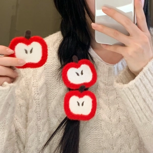 Red apple knit hair sticker accessory for bangs shown on model's braided hair