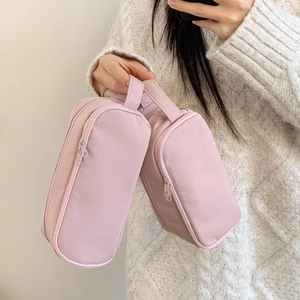 Pink minimalist cosmetic bag and pencil case with handle in a portable handheld view