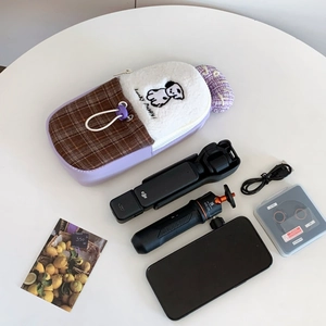 Detail of lavender leather storage bag showing embroidery and digital camera accessories