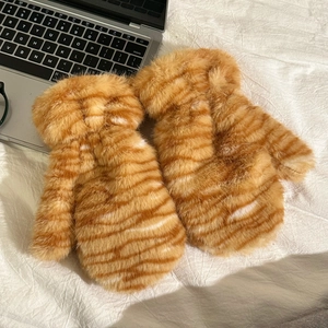 Detailed texture of plush tiger-striped mittens showing soft orange and white faux fur
