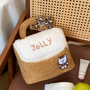 Detail of suede makeup bag featuring Hello Kitty embroidery and leopard print bow