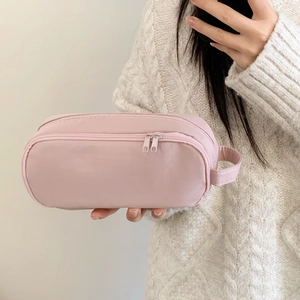 Detail view of pink multi-functional storage bag with double zippers and side handle