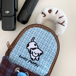 Detail of checkered digital camera bag featuring cute puppy embroidery and soft fleece handle