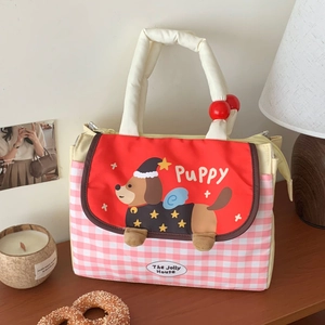 Cute puppy lunch bag with red lid and pink checkered pattern on a wooden table