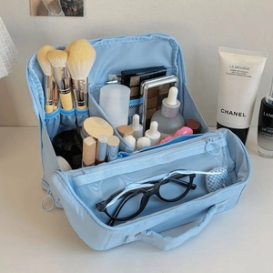 Detail view of large capacity blue makeup bag showing brush slots and internal compartments