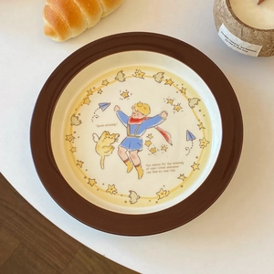 Detail view of Little Prince ceramic plate with hand-painted star illustrations on white desk