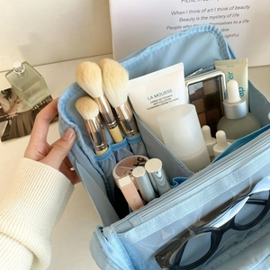 Detail view of large capacity makeup bag with organized compartments and brush slots