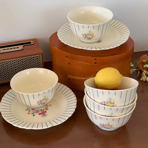 Macro view of vintage ceramic bowls and plates featuring blue stripes and floral patterns