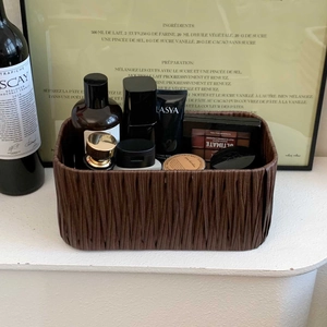 Detailed view of a vintage woven storage basket organized with cosmetics on a tabletop