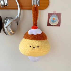 Detail of yellow pudding plush night light hanging on a wooden hook in a cozy setting