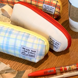 Detailed close-up of quilted plaid stationery pouches in various vibrant colors
