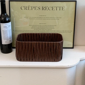 Detail of dark brown woven storage basket used as a French style home decor element