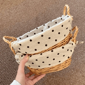 Detail view of oval wicker baskets with polka dot fabric lining and dual woven handles