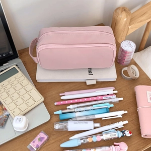 Close-up of pink canvas stationery bag with zippers and organized storage compartments