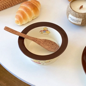 Detail of Little Prince ceramic bowl with star patterns and a natural wooden spoon