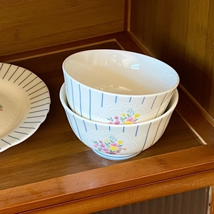 Close-up of vintage ceramic bowls with blue stripes and delicate floral patterns