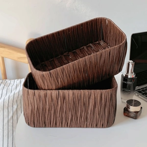 Close-up of hand-woven dark brown storage baskets for desktop cosmetic organization
