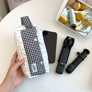 Gros plan d'une trousse en tissu à carreaux avec dragonne et fermeture éclair pratique