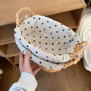 Detailed view of hand-woven wicker basket with polka dot lining and dual side handles