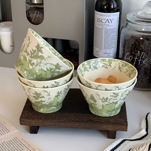 Detail of lily of the valley ceramic bowls featuring elegant floral patterns and creamy glaze
