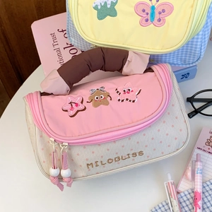 Detailed close-up of corduroy pencil case with star embroidery and soft pink handle