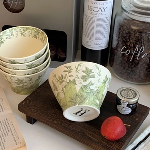 Detailed macro view of the fine bone porcelain bowl base with H logo and floral pattern