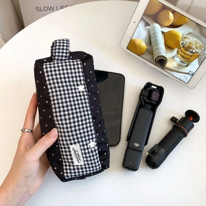 Détail d'une pochette de rangement à pois contenant un stabilisateur et un smartphone