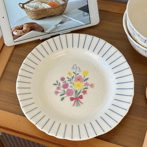 Detail of vintage ceramic bowl with delicate floral pattern and blue striped rim texture