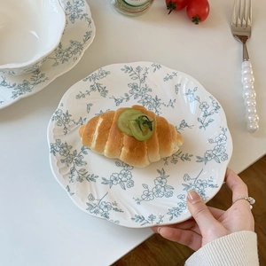 Detailed top view of French vintage floral ceramic plate with embossed wavy edges and croissant