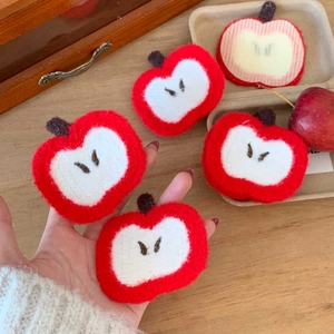 Macro shot of cute apple-shaped plush hair clip with vibrant red and white felt texture