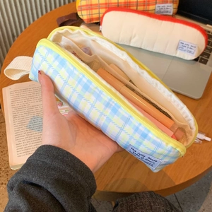 Detail of quilted plaid pencil case with yellow zipper and internal mesh divider